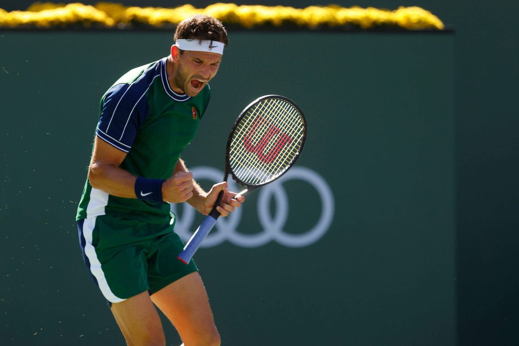 Grigor Dimitrov celebrating on Indian Wells tennis court wearing green athletic kit intense moment Wallpaper