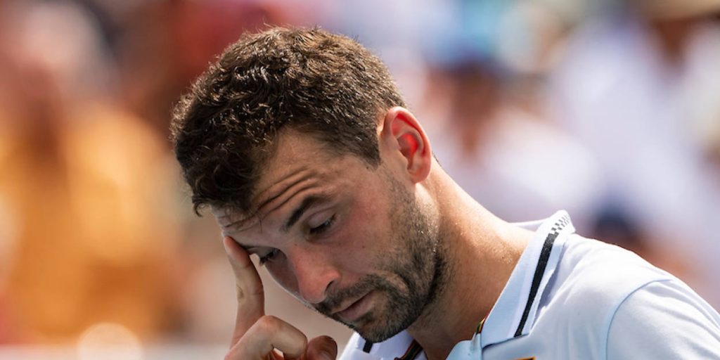 Close-up of frustrated tennis player Grigor Dimitrov in white kit on sunlit blurred court background Wallpaper
