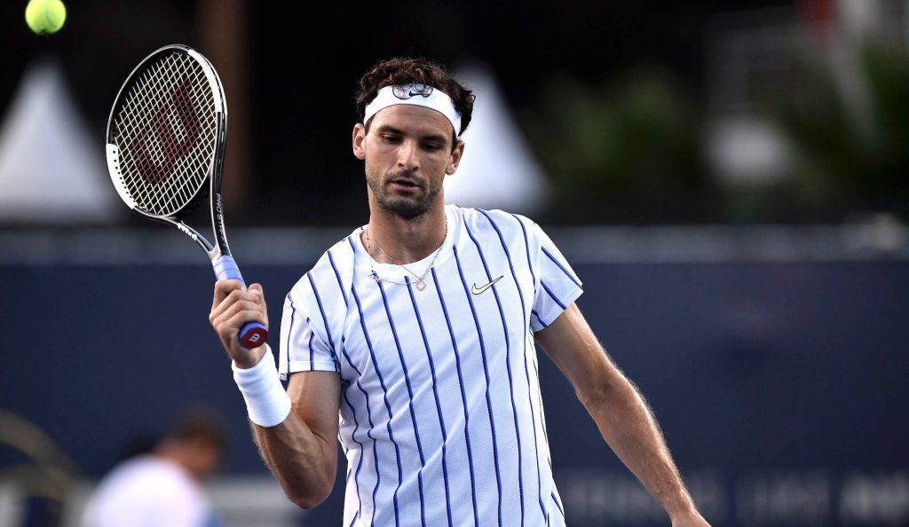 Pro tennis player Grigor Dimitrov focused in white shirt with Wilson racket on court action shot Wallpaper