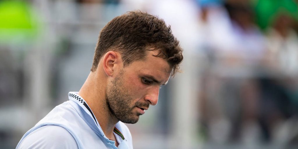 Grigor Dimitrov focused in light blue polo tennis portrait with blurred stadium background wallpaper