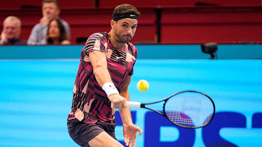 Grigor Dimitrov hitting powerful forehand in maroon top with intense focus blue tennis court Wallpaper