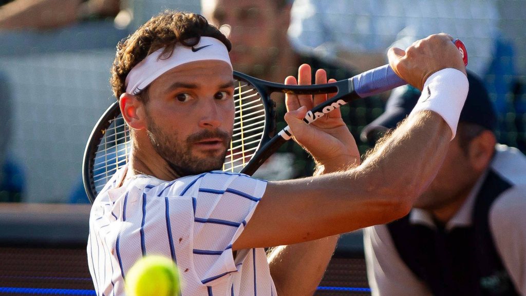 Tennis pro Grigor Dimitrov in white headband focused mid-swing with Wilson racket outdoors Wallpaper