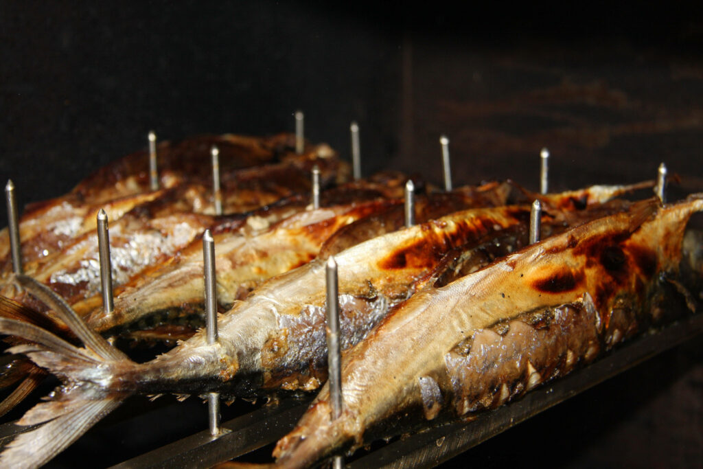 Grilled Mackerel Close-Up: Charred Texture on Dark Wallpaper