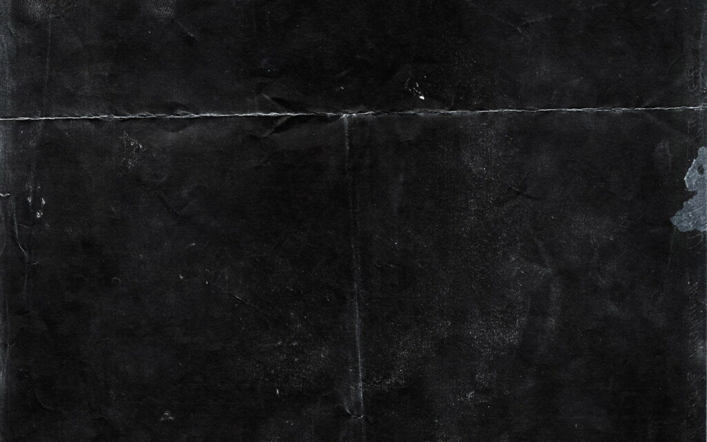4K gritty grunge wallpaper with textured distressed black surface and moody dusty creases background