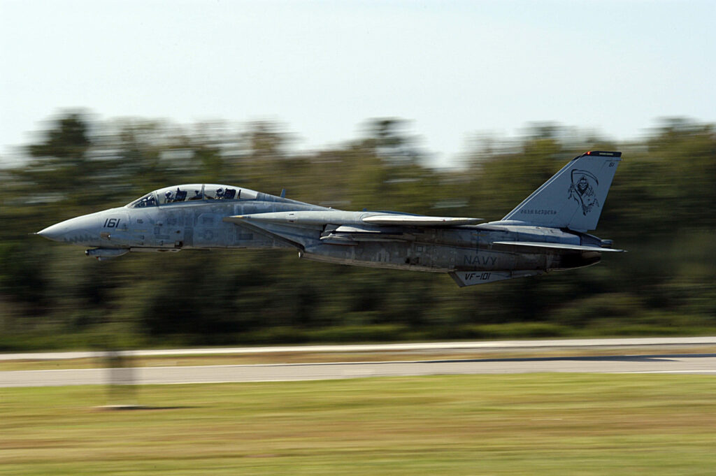 Grumman F-14 Tomcat fighter jet soaring low in flight with blurred motion background wallpaper