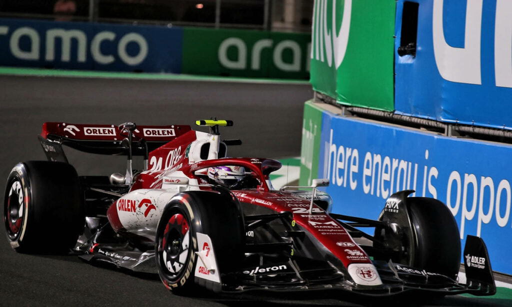 Guanyu Zhou driving Alfa Romeo Formula 1 car at high speed on Saudi Arabian Grand Prix night circuit Wallpaper