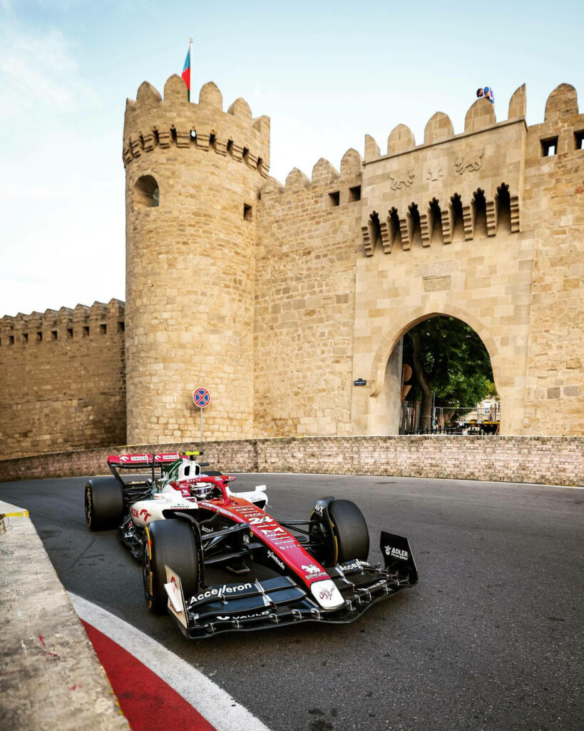 Guanyu Zhou racing Formula 1 car past historic city walls Azerbaijan Grand Prix wallpaper background