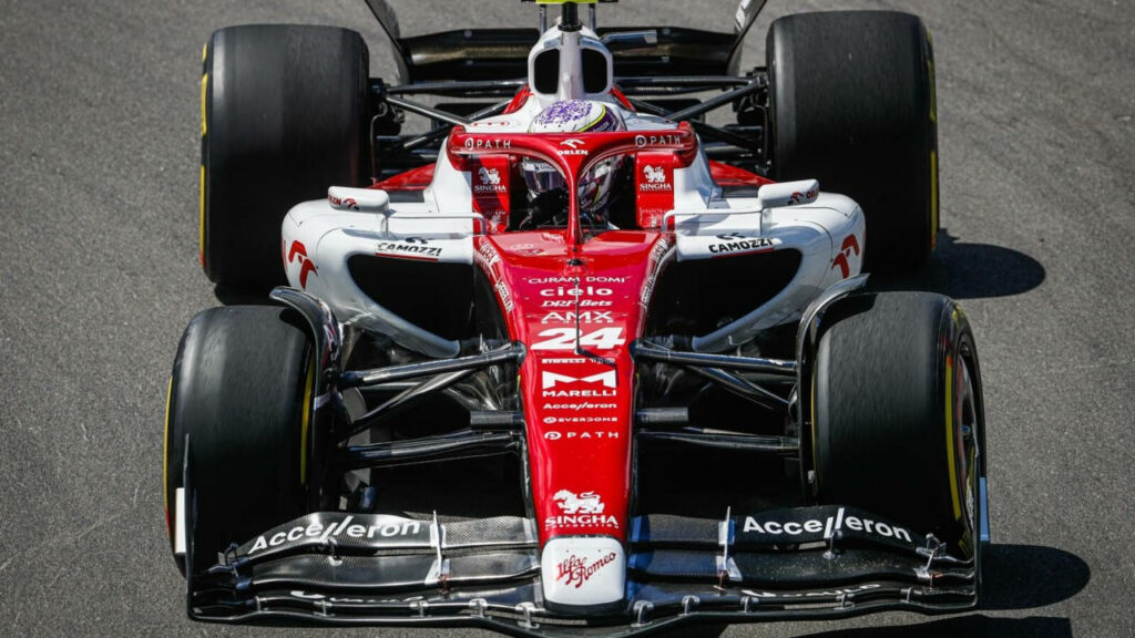 Guanyu Zhou driving Formula 1 car intensely on race track dynamic high speed wallpaper background