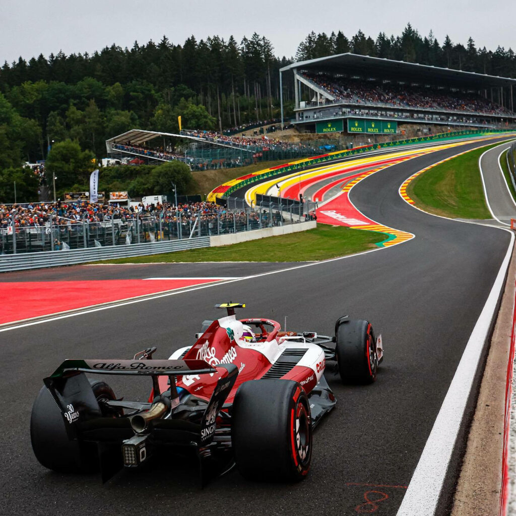 Guanyu Zhou racing Alfa Romeo at Eau Rouge Belgian Grand Prix vibrant crowd lush forest background Wallpaper
