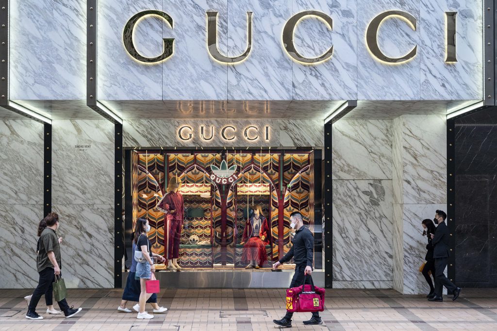 Gucci x Adidas storefront with stylish mannequins vibrant backdrop high fashion 4K wallpaper