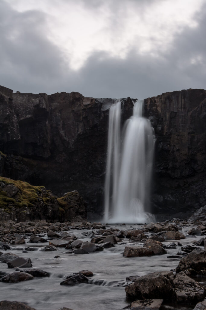 Gufufoss waterfall in Iceland cascading over volcanic rocks with mist under overcast sky wallpaper