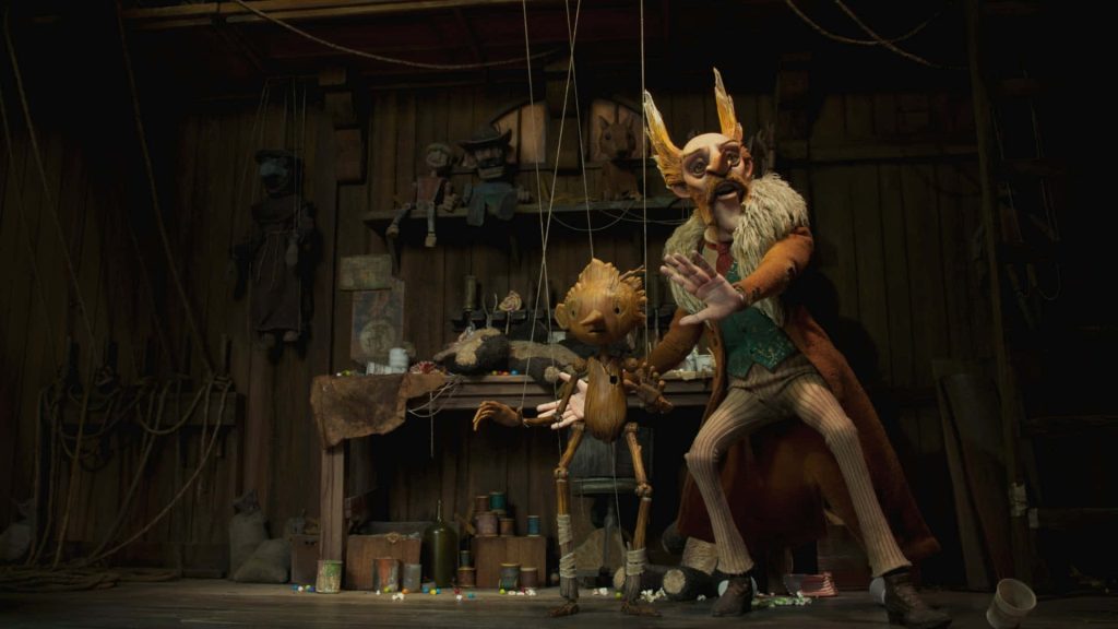 Pinocchio and Count Volpe in rustic wood workshop moody lighting Guillermo del Toro wallpaper