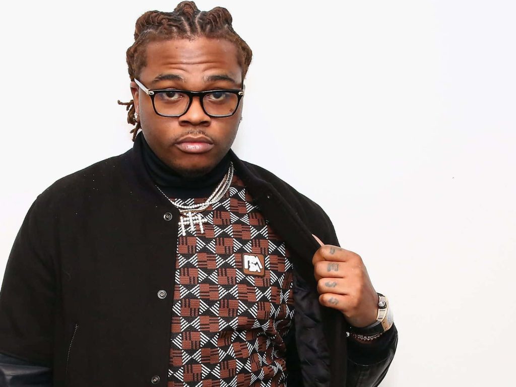 Gunna rapper in SiriusXM studio wearing geometric sweater black jacket and signature braids Wallpaper