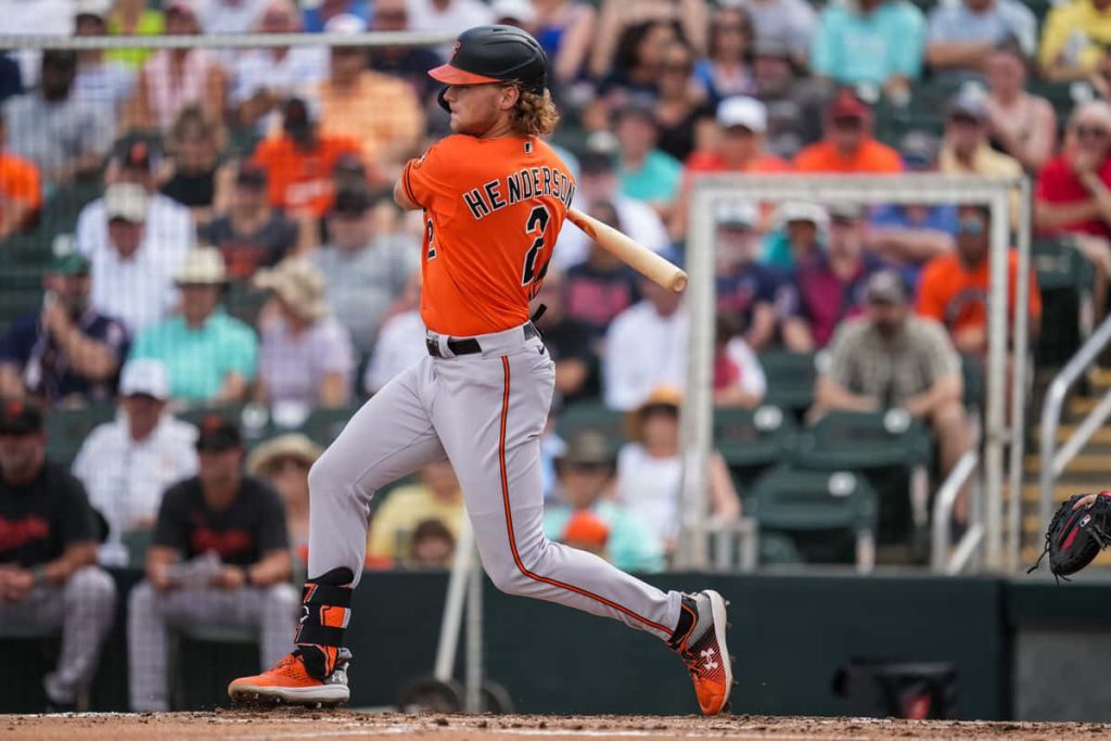 Baltimore Orioles Gunnar Henderson mid-swing in orange jersey intense MLB game action wallpaper