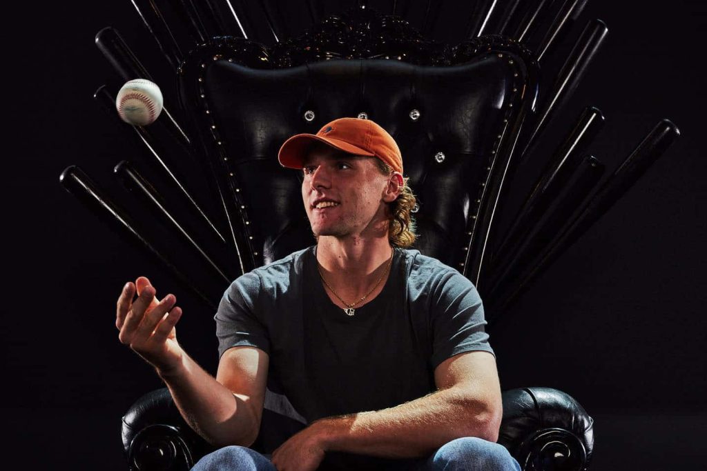 MLB star Gunnar Henderson catching ball on custom black bat throne with dramatic dark background Wallpaper