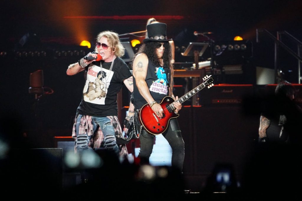 Guns N Roses live concert Axl Rose singing Slash playing guitar rock and roll stage lighting Wallpaper