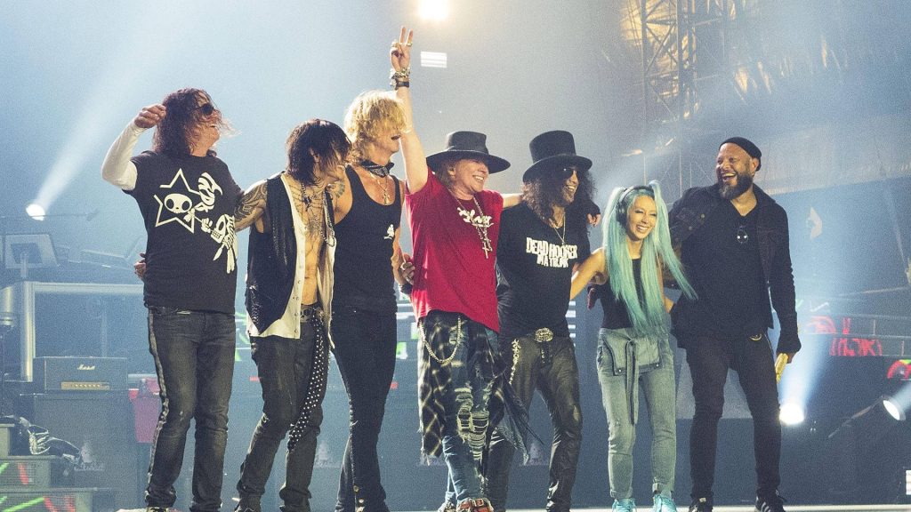 Guns N Roses live concert wallpaper with Axl Rose Slash bowing under bright stage lights