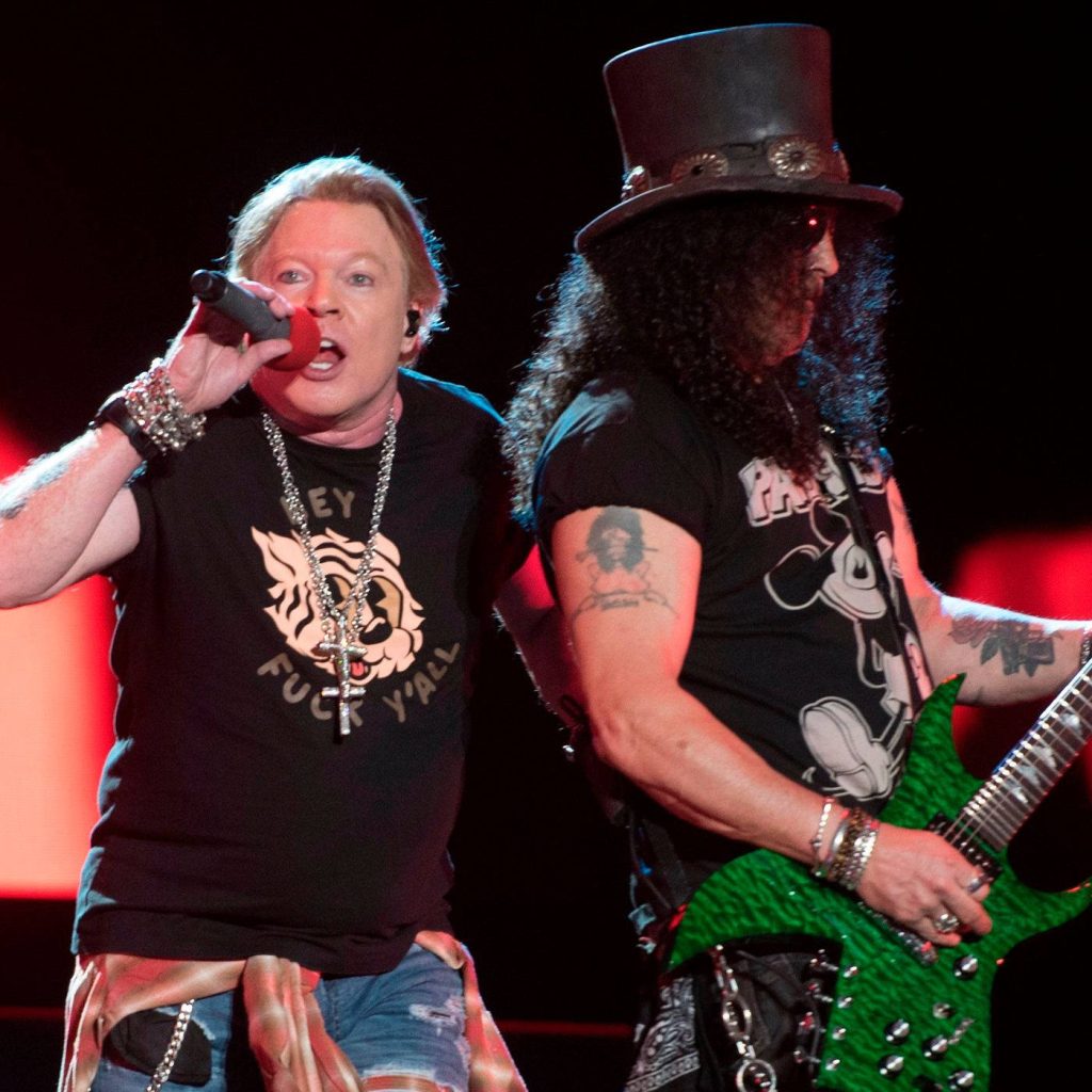 Guns N Roses live concert with Axl Rose singing and Slash playing green guitar on stage Wallpaper