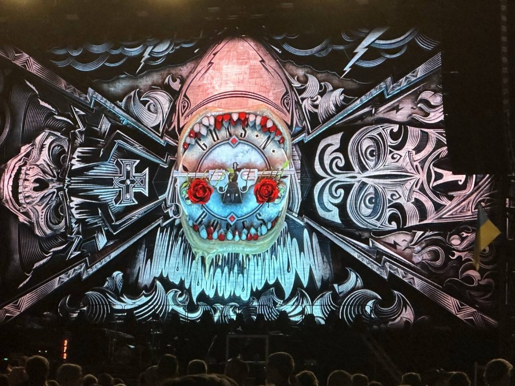 Guns N' Roses concert backdrop with shark jaw roses pistols vibrant rock band logo wallpaper