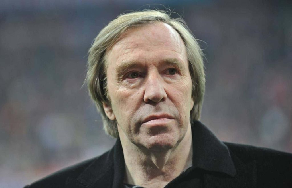 Close-up portrait of German football legend Günter Netzer with iconic blonde hair wallpaper