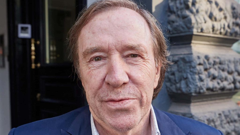 Günter Netzer portrait in blue blazer outdoor background legendary German footballer close-up Wallpaper