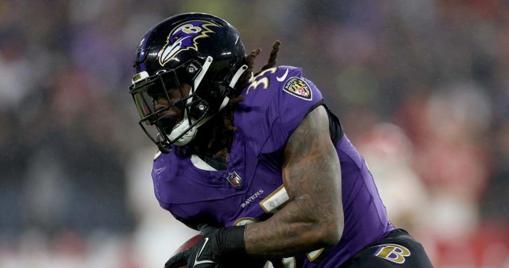 Gus Edwards Baltimore Ravens running back in purple jersey intense NFL football action shot Wallpaper