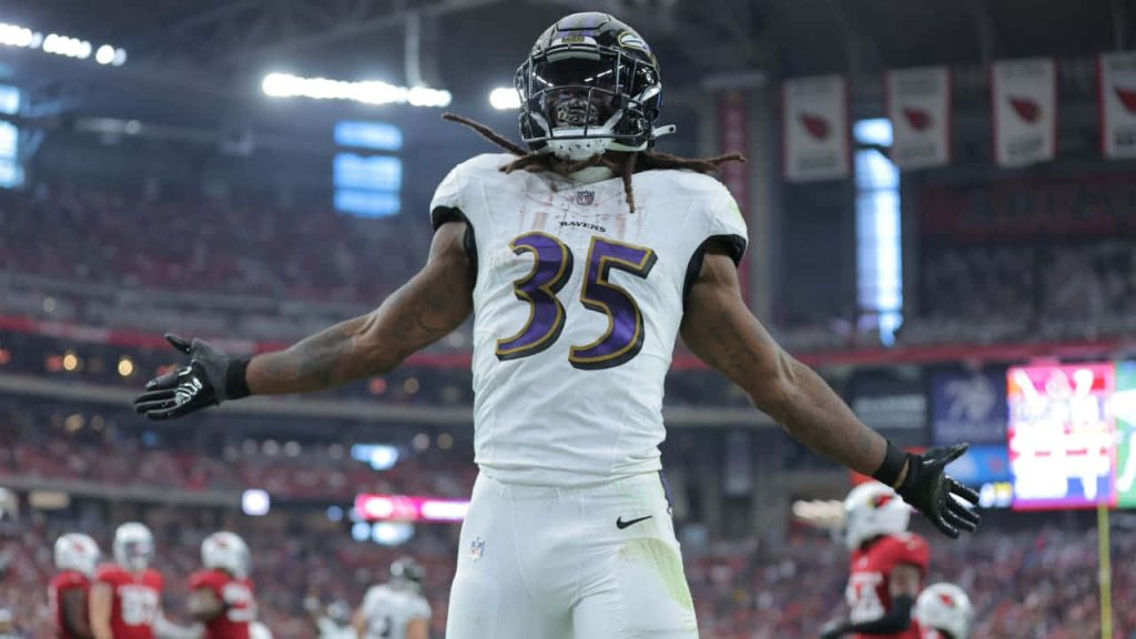 Gus Edwards Baltimore Ravens celebrating in white jersey NFL action shot stadium wallpaper