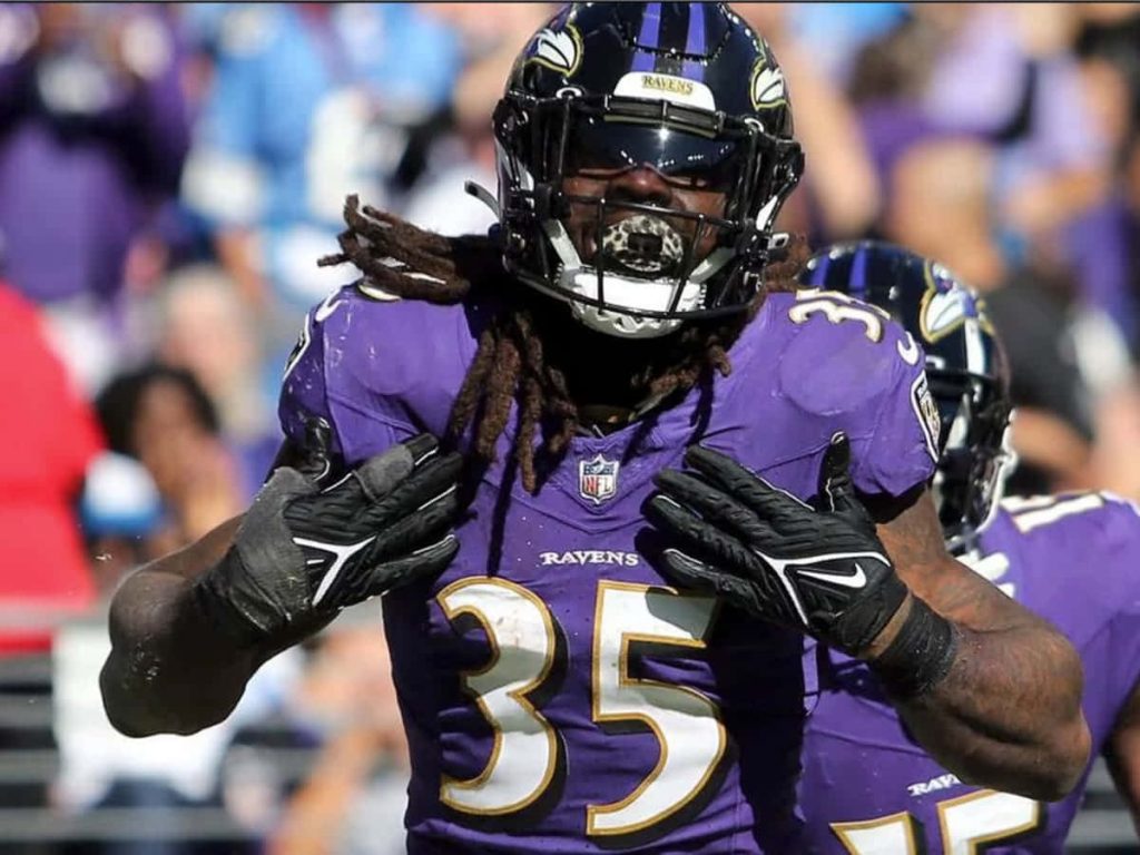 Baltimore Ravens Gus Edwards in purple jersey 35 celebrates intense NFL action vibrant wallpaper