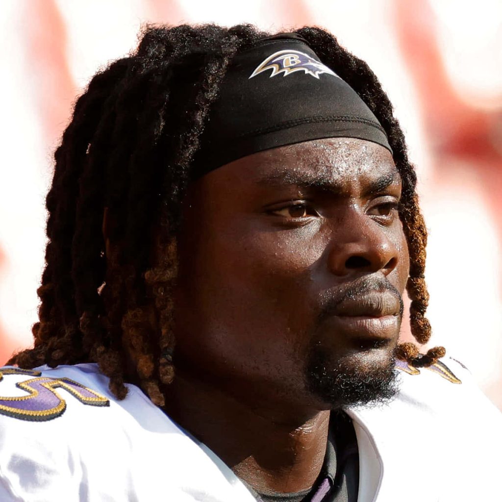 Gus Edwards Baltimore Ravens NFL running back intense focused portrait white jersey dreadlocks Wallpaper