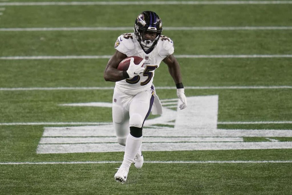 Baltimore Ravens Gus Edwards sprinting in white jersey 35 NFL action sports wallpaper background
