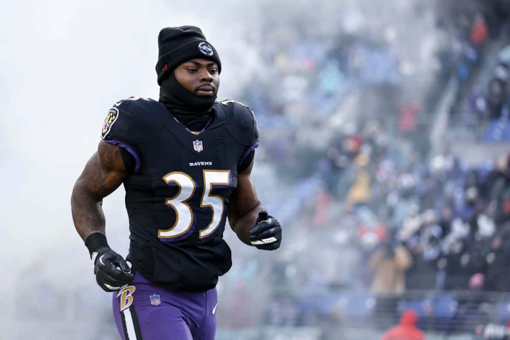 Baltimore Ravens running back Gus Edwards number 35 charging on field NFL game day energy wallpaper