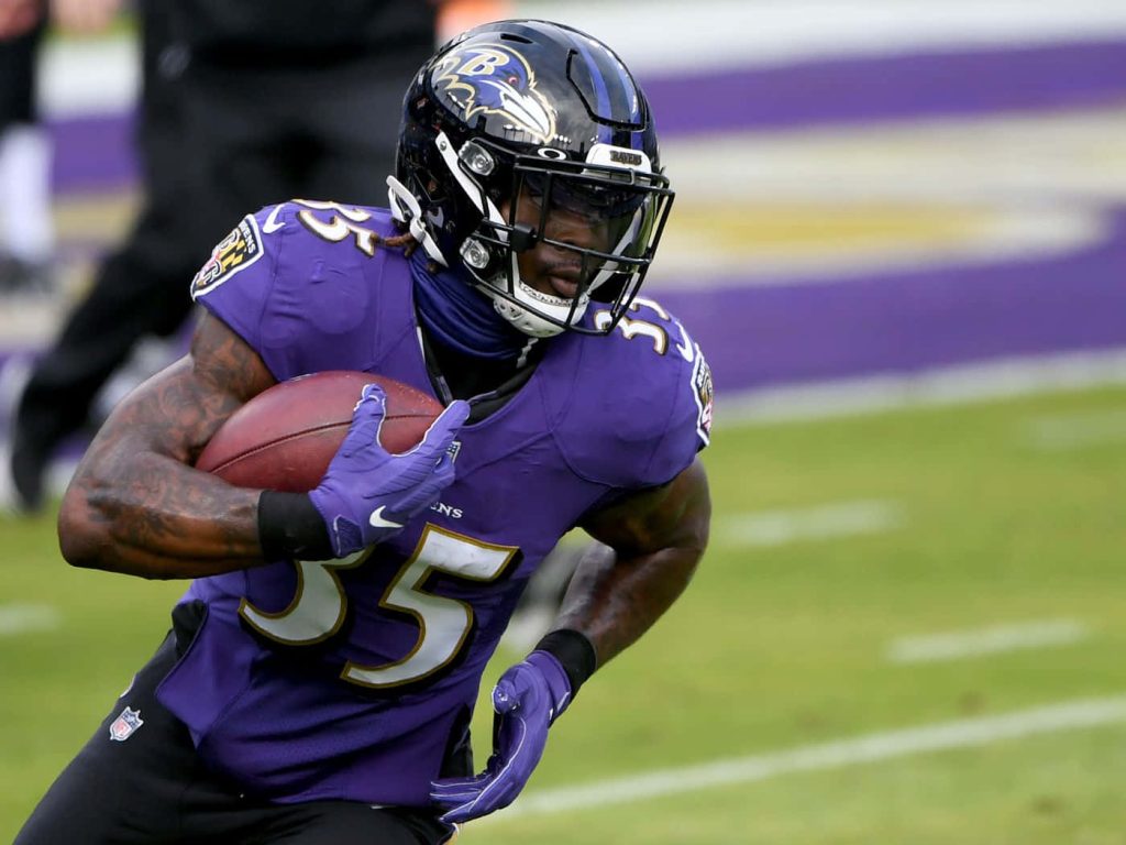 Gus Edwards Baltimore Ravens running back sprinting with football NFL action wallpaper background