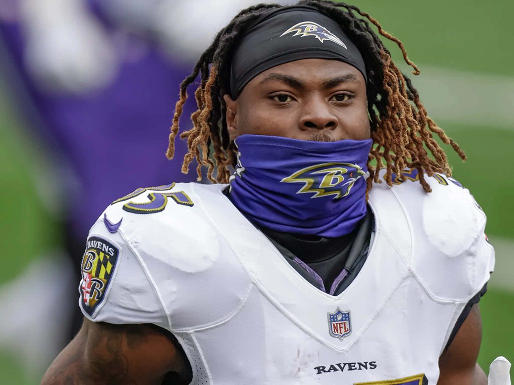 Gus Edwards Baltimore Ravens portrait in white uniform and purple gaiter intense game day wallpaper