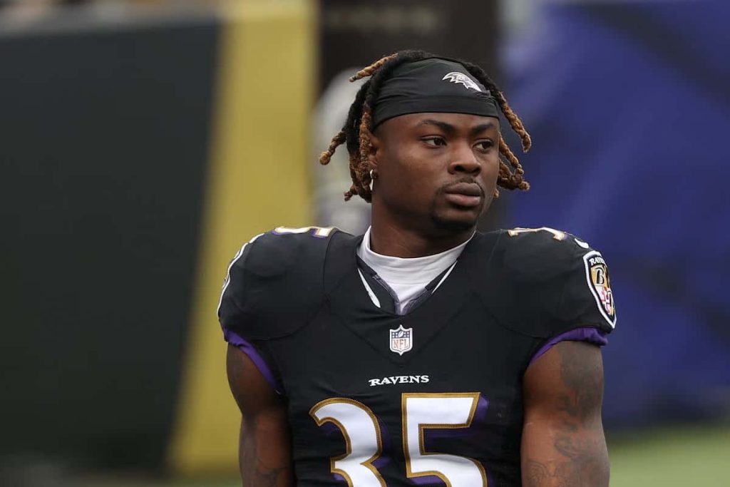 Gus Edwards Baltimore Ravens running back in black jersey number 35 focused stadium background Wallpaper
