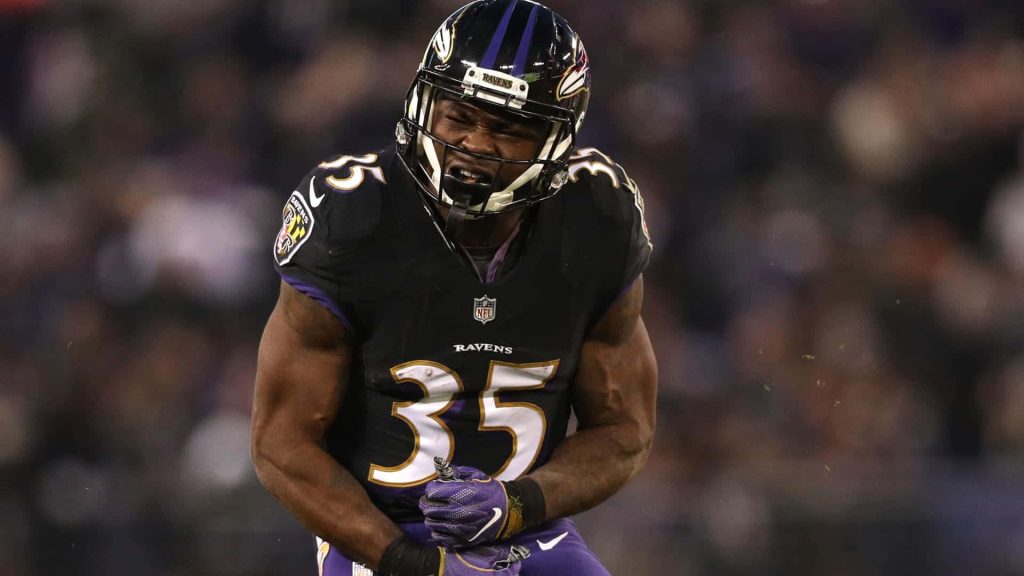 Gus Edwards Baltimore Ravens running back in black jersey 35 intense game action NFL wallpaper
