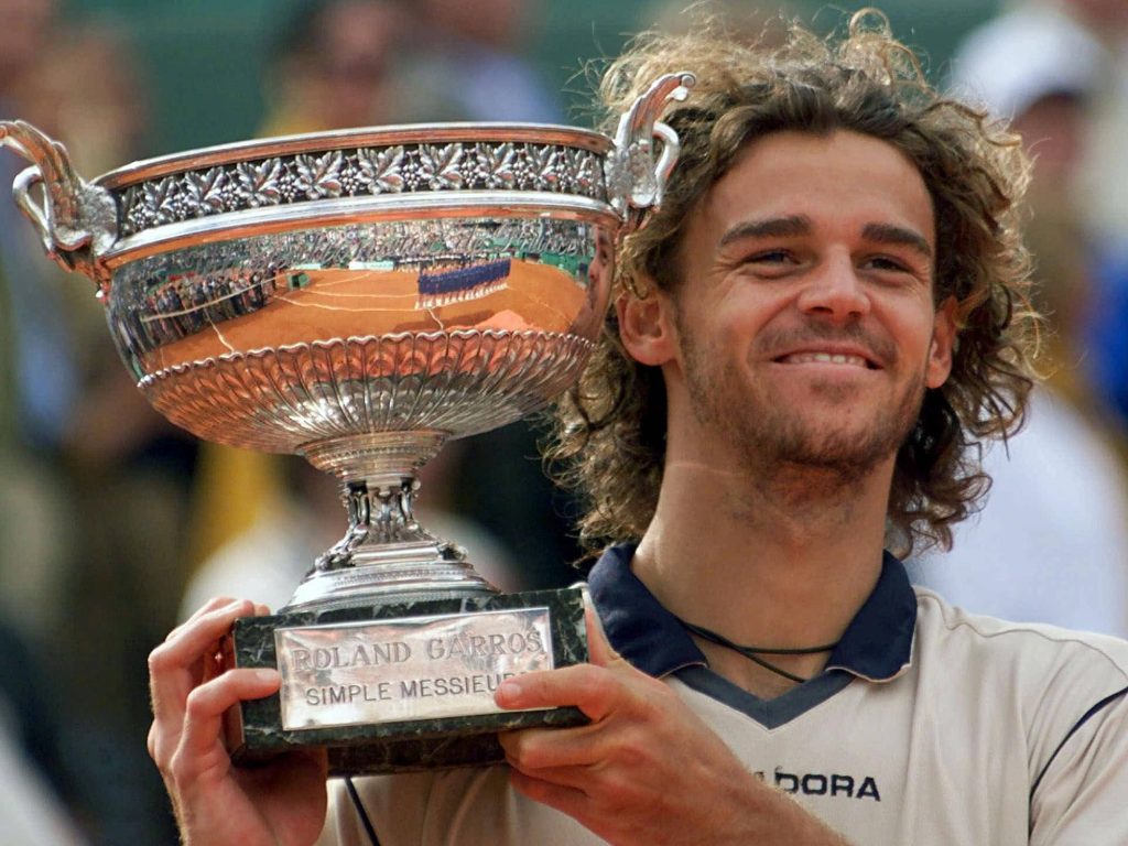 Gustavo Kuerten smiling with Roland-Garros trophy showing clay court reflection tennis legend Wallpaper