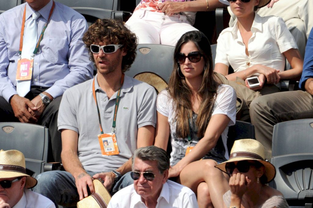Gustavo Kuerten wearing sunglasses and lanyard watching Roland Garros tennis match in stands Wallpaper
