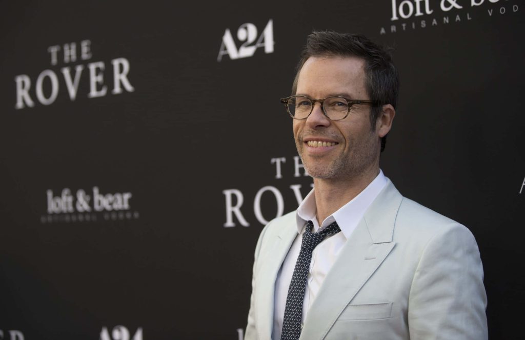 Guy Pearce in light suit smiling at The Rover premiere A24 red carpet professional photo wallpaper