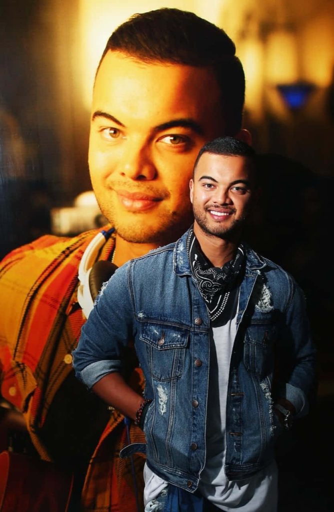 Digital collage wallpaper of Australian singer Guy Sebastian in denim jacket with orange background