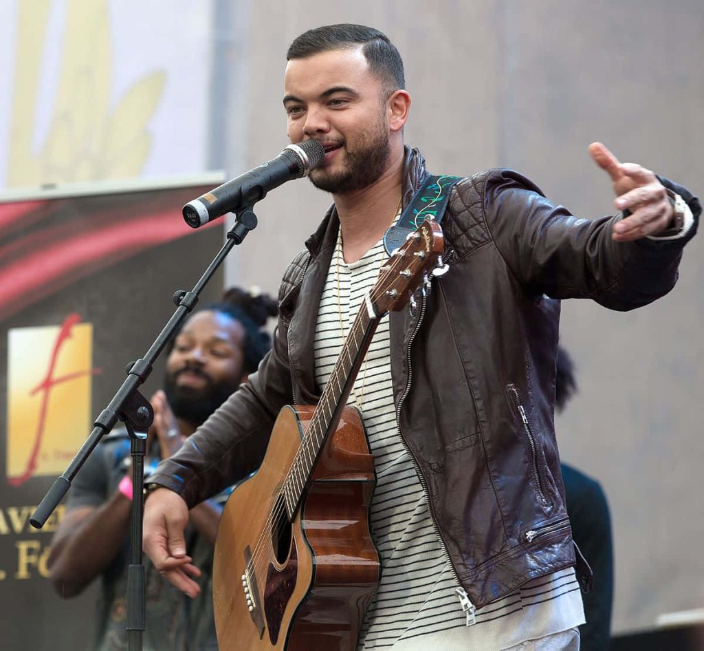 Guy Sebastian live performance acoustic guitar brown leather jacket vibrant music wallpaper background