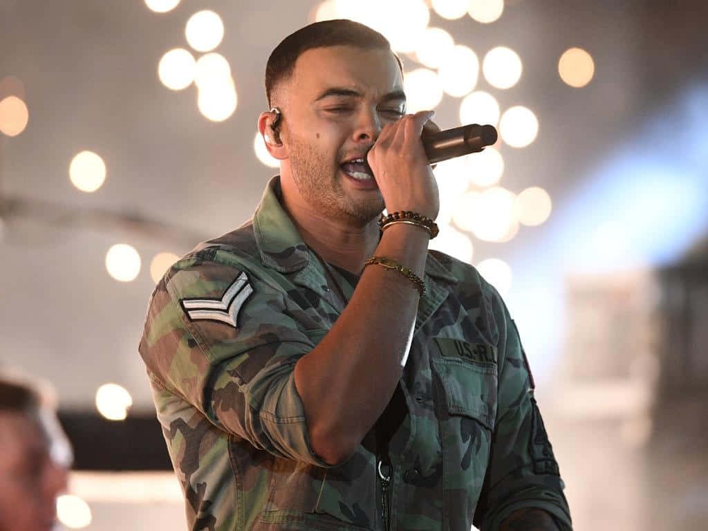 Guy Sebastian live performance wallpaper camo jacket intense concert mood bokeh lights background