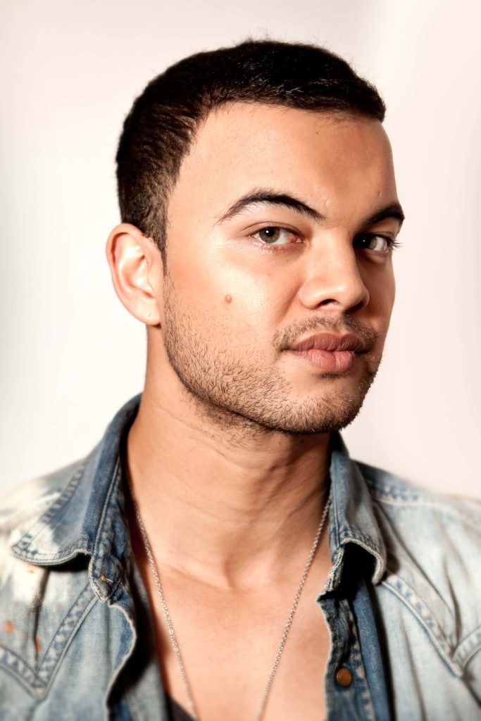 Portrait of Australian singer Guy Sebastian in denim jacket with soft studio background Wallpaper