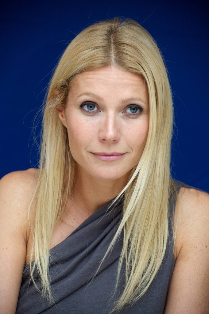 Gwyneth Paltrow portrait in gray one-shoulder top at Country Strong press conference blue background Wallpaper