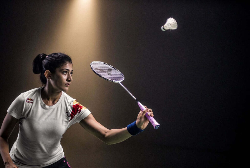 Female Badminton Player Practicing in Background Wallpaper