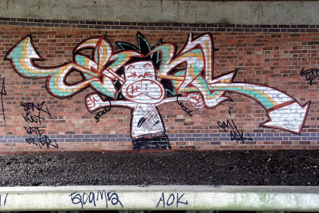 Street Art Splash: Vibrant Graffiti Unleashed on Urban Bricks Wallpaper