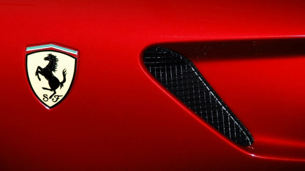 Iconic Red Ferrari 599 Logo: Vibrant Close-Up HD Wallpaper with a Striking Background