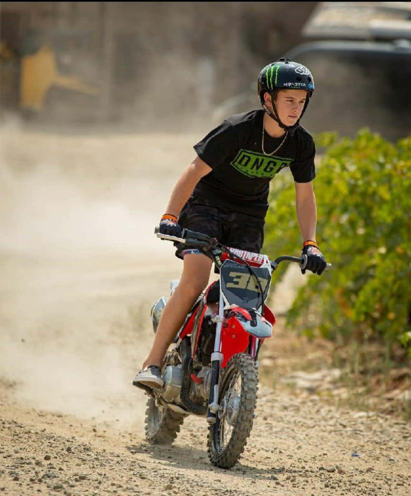 Motocross rider Haiden Deegan racing on dusty track wearing Monster Energy helmet and DNG gear Wallpaper