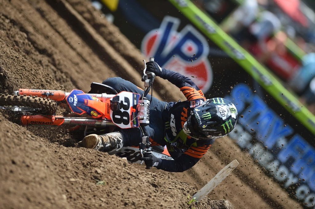 Motocross rider Haiden Deegan on KTM leaning into turn with flying dirt and Monster Energy gear Wallpaper