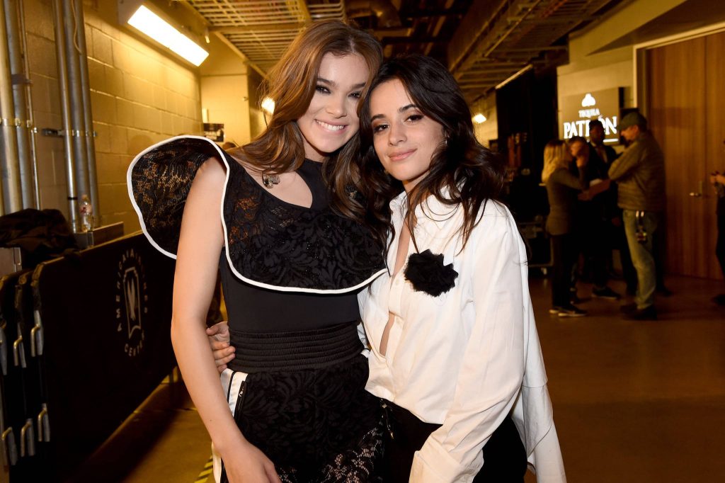 Hailee Steinfeld and Camila Cabello backstage smiling stylishly in black lace top and white shirt Wallpaper