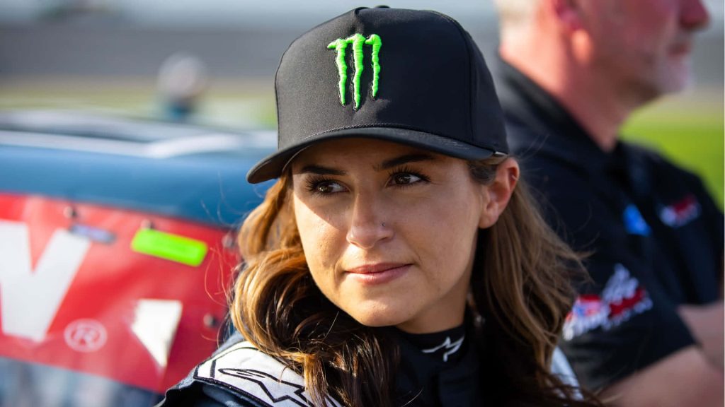 Hailie Deegan portrait in Monster Energy cap racing gear trackside blurred motorsport background Wallpaper